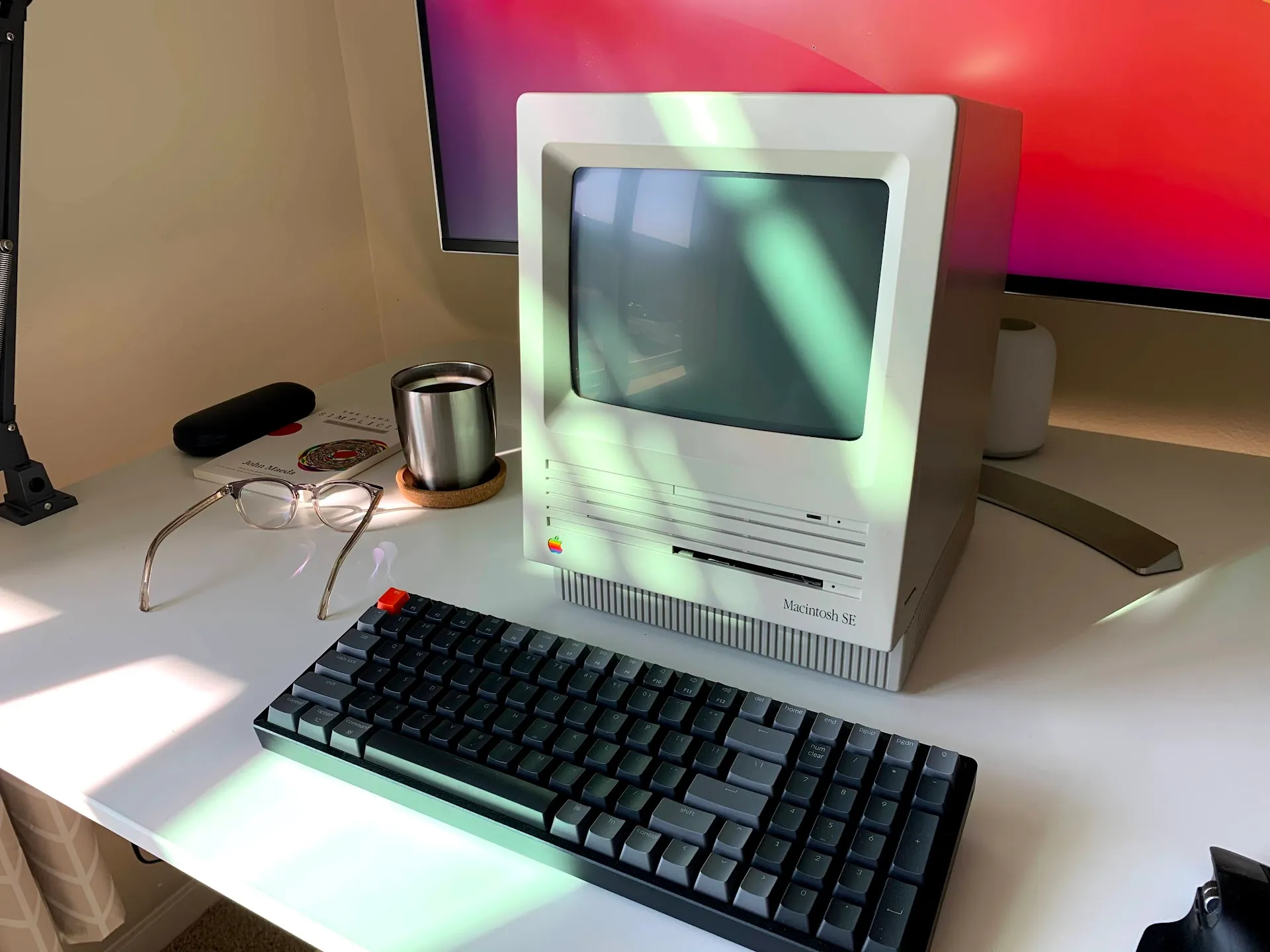 Vintage Macintosh SE on modern desk with mechanical keyboard